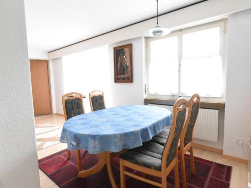 a dining room with a blue table and chairs at Modern Apartment in Mastrils near Forest in Mastrils