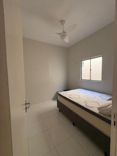 a bedroom with a bed and a window at Casa TS Morro Branco in Beberibe