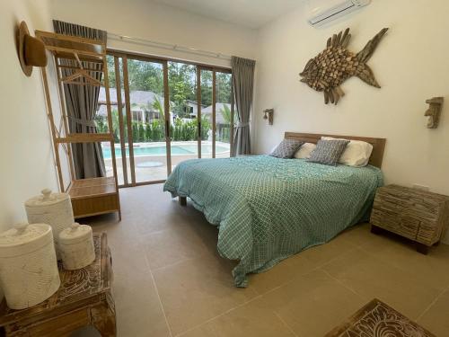 a bedroom with a bed and a view of a pool at Ubuntu Villa in Ko Phangan