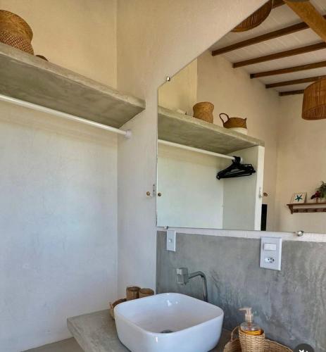 a bathroom with a white sink and a mirror at Casa Mangaba da Praia in Prado