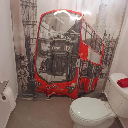 a red double decker bus in a bathroom with a toilet at Quinta Bello Cielo in Montemorelos