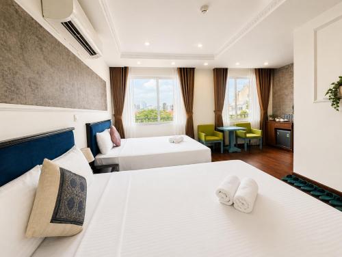a hotel room with two beds and a couch at Valoria Legend Hanoi Hotel in Hanoi