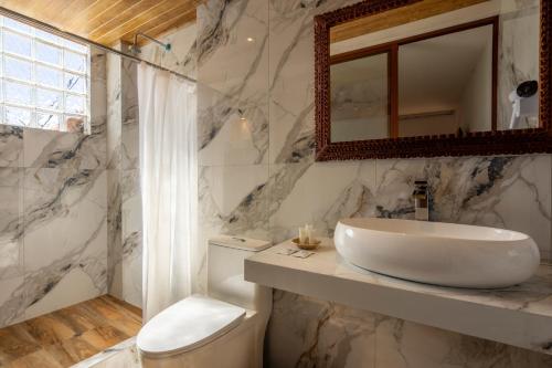 a bathroom with a sink and a toilet and a mirror at Hotel Monasterio del Inka Cusco in Cusco