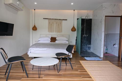 a bedroom with a bed and two chairs and a table at Hillside Koh Samui in Ban Khlong Mae Nam