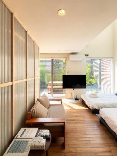 a living room with a couch and a tv at Haus128 in Sapporo