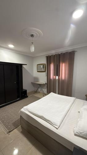 a bedroom with a large bed and a television at الدانه1 in Al Wajh