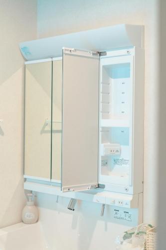 a white cabinet with a glass door in a room at AoAsoVilla in Aso