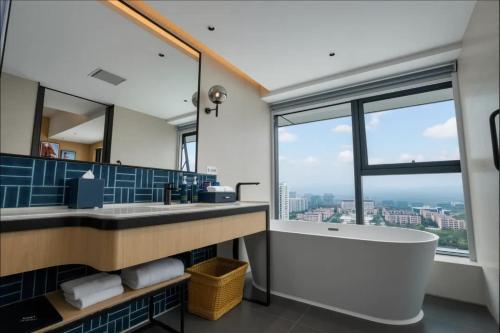 a bathroom with a tub and a large window at Four Points by Sheraton Rizhao Central Activities Zone in Rizhao