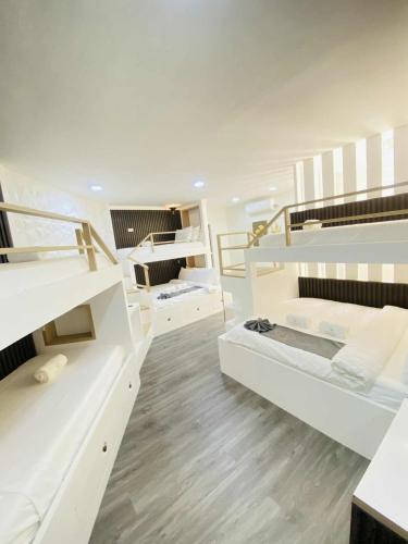 a room with white bunk beds and wooden floors at Grospe Resort Boracay in Boracay