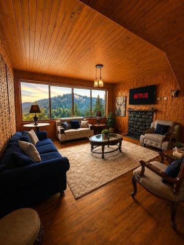 a living room with a blue couch and a fireplace at Haven Hilltop Cottage, Dunga Gali in Dunga Gali