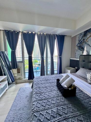 a bedroom with a large bed with blue drapes at Azure South by Dream Escapade in Manila