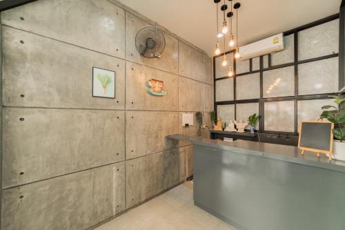 a kitchen with a counter and a wall of wood at Nawin Hotel Donmueang in Thung Si Kan