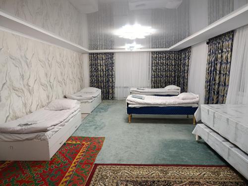 a room with three beds and a rug at Эко Жайлоо in Kaji-Say