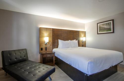 a hotel room with a bed and a chair at The Inn On 66 Flagstaff in Flagstaff