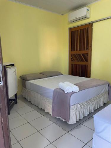a bedroom with two beds with towels on it at Pousada Taquarí Guaibim in Valença