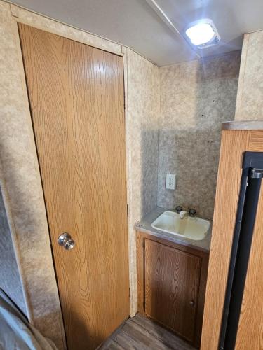 a bathroom with a sink and a wooden door at Casa Rodante Tony 2 in San Felipe