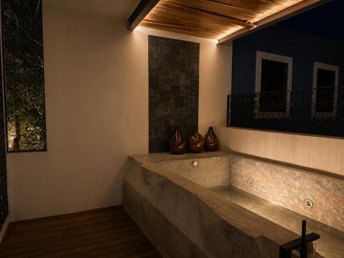a room with a bench with vases on the wall at Hotel Travertino in Mérida