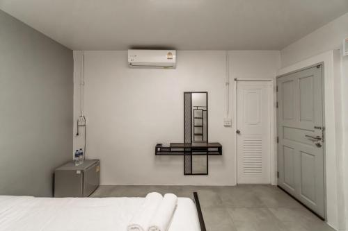 a bedroom with a bed and a mirror on the wall at Nawin Hotel Donmueang in Thung Si Kan