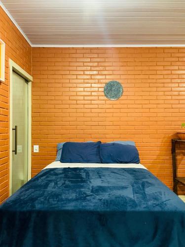 a bed in a room with a brick wall at Casa Vilarejo São Jorge in Sao Jorge