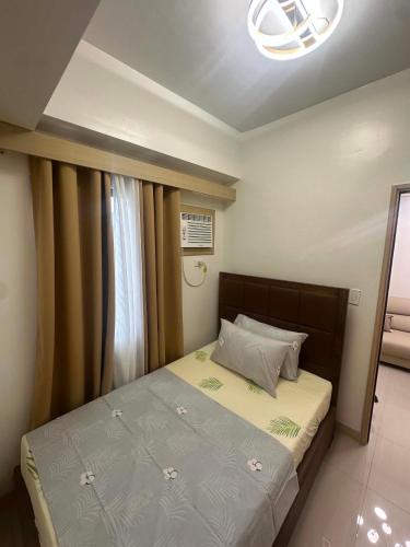 a bedroom with a bed and a window at Leaf residences 2bedroom Muntinlupa in Manila