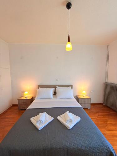 a bedroom with a large bed with two towels on it at Mega Panorama Apartments in Paleo Tsifliki