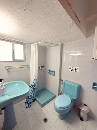 a bathroom with a blue toilet and a sink at Mega Panorama Apartments in Paleo Tsifliki