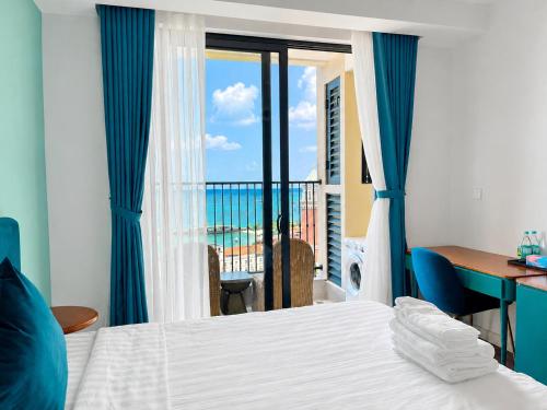 a bedroom with a bed and a view of the ocean at ELIO PHÚ QUỐC - Hillside Residence in Phú Quốc
