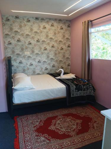 a bedroom with a bed and a wall with a window at Varattumedu Hill in Vagamon