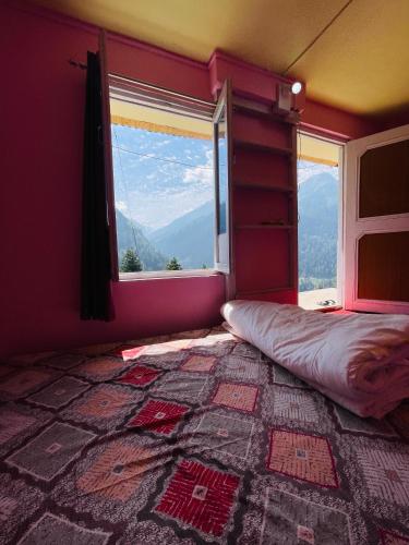 a bedroom with a bed and a large window at Skyblue cafe in Tosh