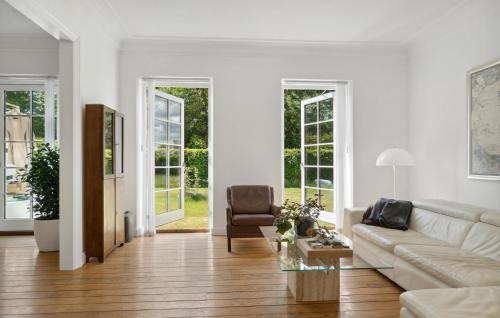a white living room with a couch and a chair at Nice Home In Idestrup With Wifi in Idestrup
