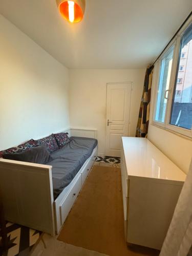a bedroom with a bed and a desk and a window at Maison Velours - LIMITLESS in Champigny-sur-Marne