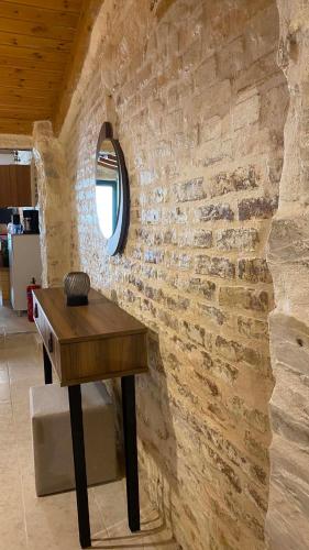 a wooden table in a room with a stone wall at CASA THEOTOKI in Anemómylos