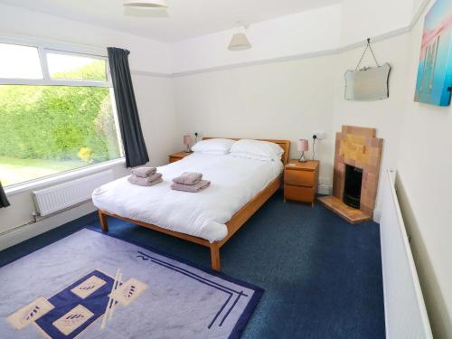 a bedroom with a large bed and a fireplace at White Thorns in Haverfordwest