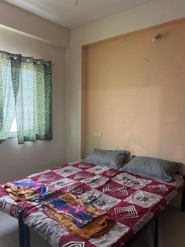 a bed with a quilt on it in a bedroom at Suyakshi homestay in Pune