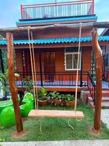 a swing in front of a house at PhaluaiHomestay พะลวยโฮมสเตย์ บ้านไม้ in Koh Phaluai