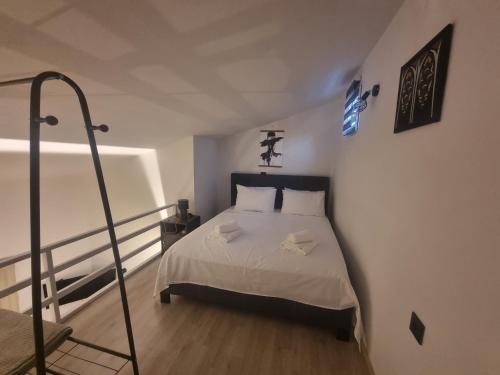 a bedroom with a bed with white sheets at SmallHouseLefkada ΘΕΜΑ in Lefkada