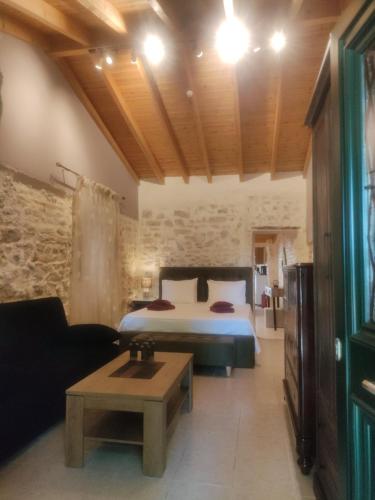 a bedroom with a bed and a couch and a table at CASA THEOTOKI in Anemómylos