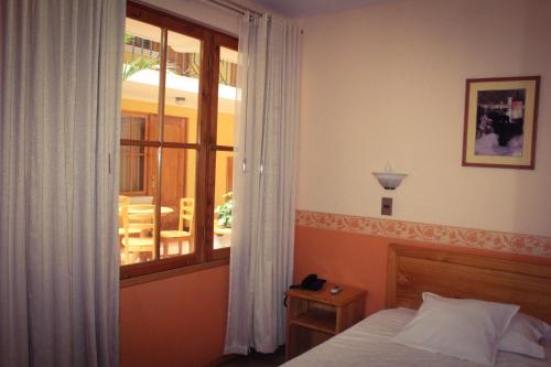 a bedroom with a bed and a window at Colonia Real in Sucre