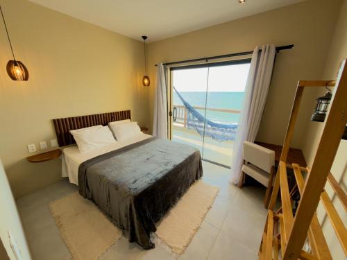 a bedroom with a bed with a view of the ocean at Dona Chica Wellness Center in Taíba