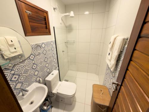 a small bathroom with a toilet and a sink at Dona Chica Wellness Center in Taíba