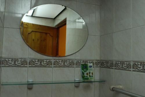 a bathroom mirror with a wooden door and a glass shelf at Colonia Real in Sucre