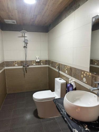 a bathroom with a sink and a toilet and a tub at TaVan Eco Home in Tả Van