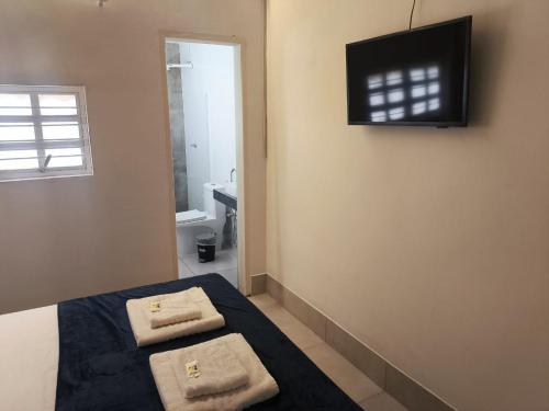 a bedroom with a bed with two towels on it at Gyn Suítes - Suítes novas e funcionais in Goiânia
