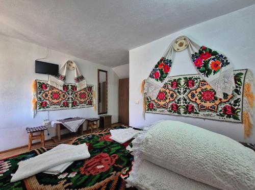 a bedroom with a bed and blankets on the wall at Casa Grigor in Călineşti
