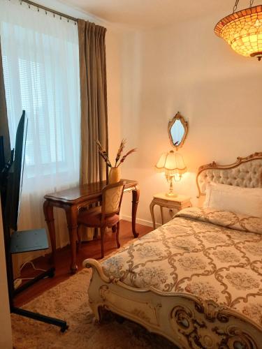 a bedroom with a bed and a desk and a window at Bed and Breakfast in Old Town in Naujoji Akmenė