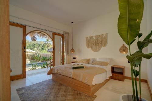 a bedroom with a bed and a large window at Bellis Garden in Kuta Lombok