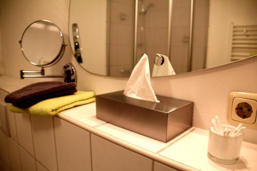 ein Badezimmer mit einem Spiegel und einer Schachtel Taschentücher in der Unterkunft Ferienhof Schugg in Missen-Wilhams