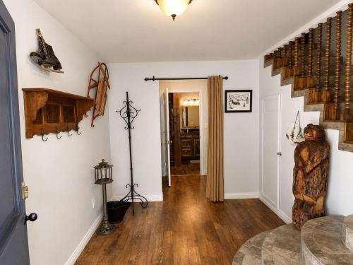 a living room with a staircase and a wooden floor at Chalet Rouge in Ruidoso