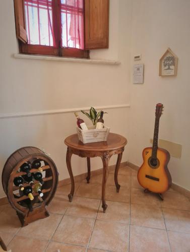 ein Zimmer mit einem Tisch, auf dem eine Gitarre und Weinflaschen stehen in der Unterkunft Il Camerone in Isola del Liri
