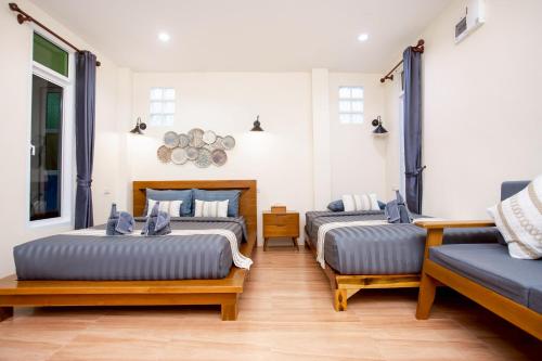 a room with two beds and a couch at Khaosok Bamboo Huts Resort in Khao Sok National Park